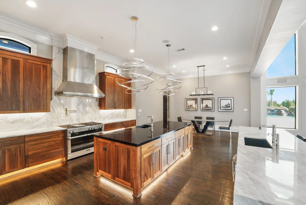 1252 Wales Drive Home in Rockwall, Texas. Step into luxury living at its finest with this illustrious estate set on over two private acres. Enjoy resort-style amenities including a pool with swim-up bar, fire features, waterfalls, and a covered patio with motorized screens.