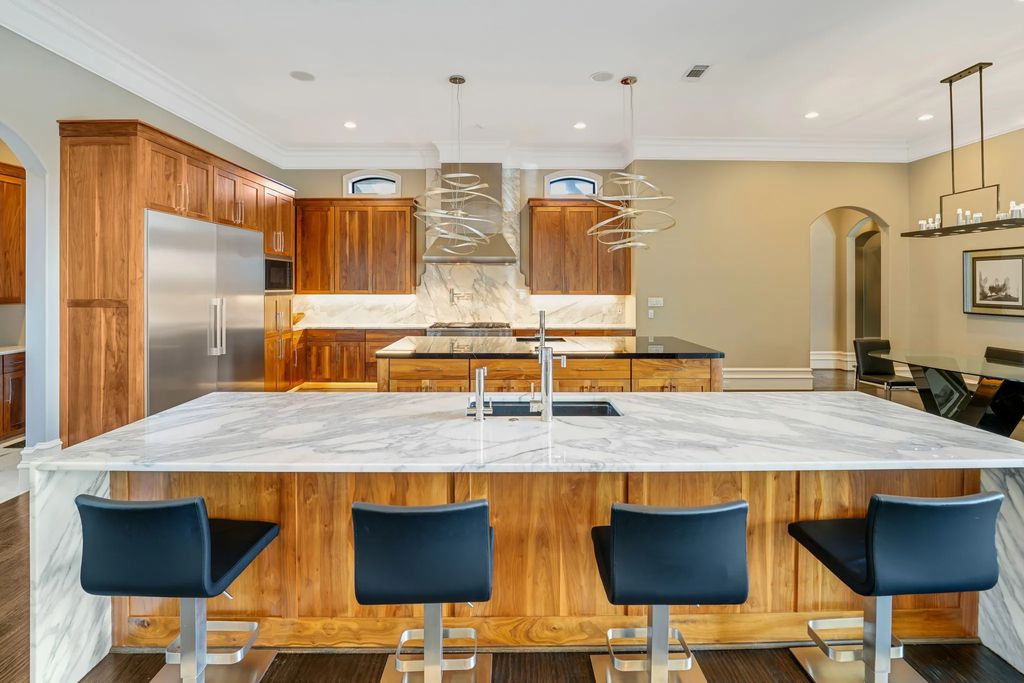 1252 Wales Drive Home in Rockwall, Texas. Step into luxury living at its finest with this illustrious estate set on over two private acres. Enjoy resort-style amenities including a pool with swim-up bar, fire features, waterfalls, and a covered patio with motorized screens.