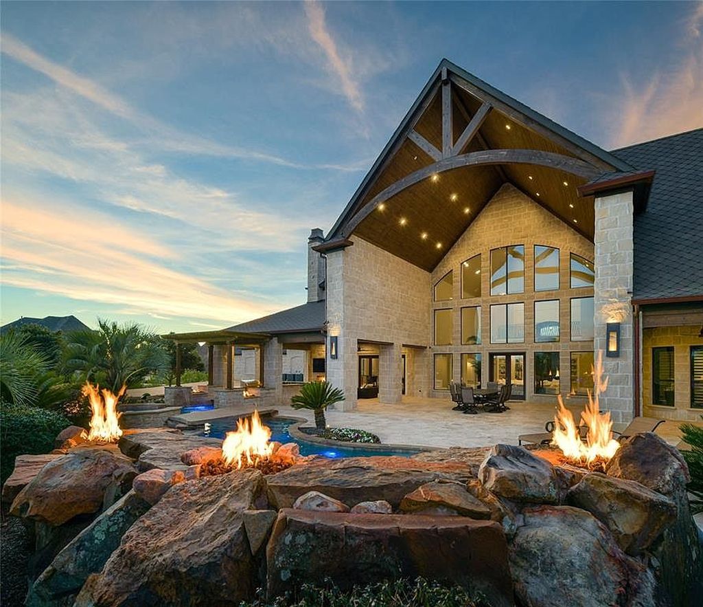 1252 Wales Drive Home in Rockwall, Texas. Step into luxury living at its finest with this illustrious estate set on over two private acres. Enjoy resort-style amenities including a pool with swim-up bar, fire features, waterfalls, and a covered patio with motorized screens.