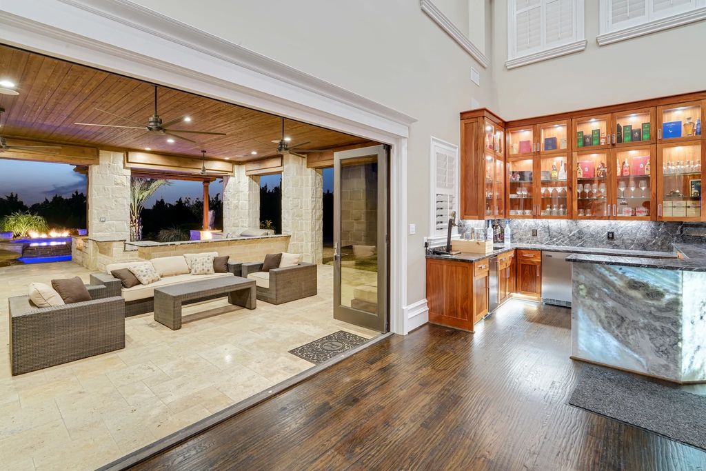 1252 Wales Drive Home in Rockwall, Texas. Step into luxury living at its finest with this illustrious estate set on over two private acres. Enjoy resort-style amenities including a pool with swim-up bar, fire features, waterfalls, and a covered patio with motorized screens.