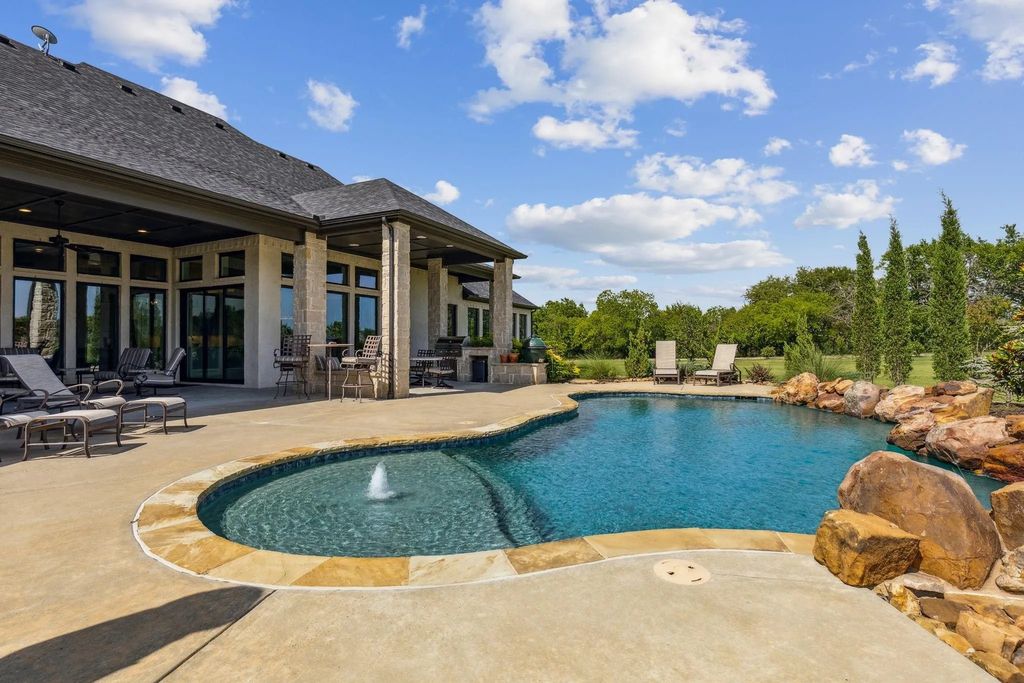 1621 Jan Marie Drive Home in Lucas, Texas. Discover unparalleled luxury in this custom J. Anthony home quietly nestled on a 2-acre north-facing cul-de-sac in prestigious Lovejoy ISD. Featuring exceptional design, premium fixtures, and abundant natural light, this home offers an open concept living area with exposed beams and a gourmet kitchen with dual islands and quartz countertops.