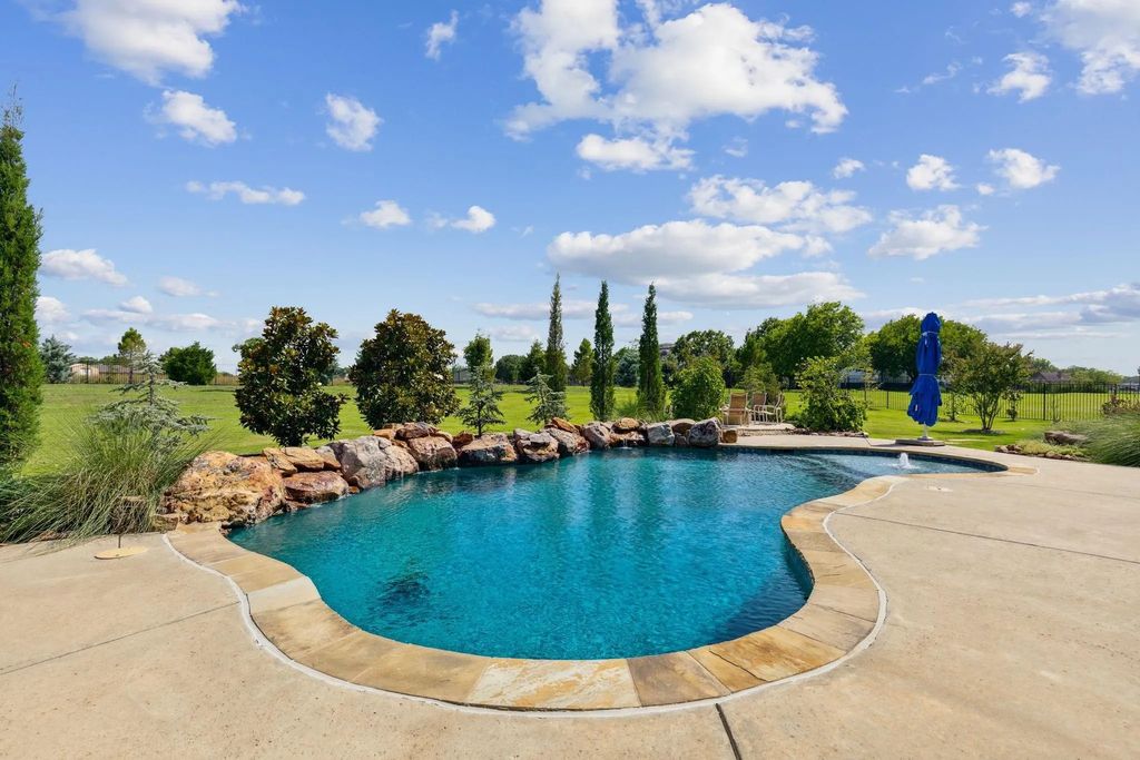 1621 Jan Marie Drive Home in Lucas, Texas. Discover unparalleled luxury in this custom J. Anthony home quietly nestled on a 2-acre north-facing cul-de-sac in prestigious Lovejoy ISD. Featuring exceptional design, premium fixtures, and abundant natural light, this home offers an open concept living area with exposed beams and a gourmet kitchen with dual islands and quartz countertops.