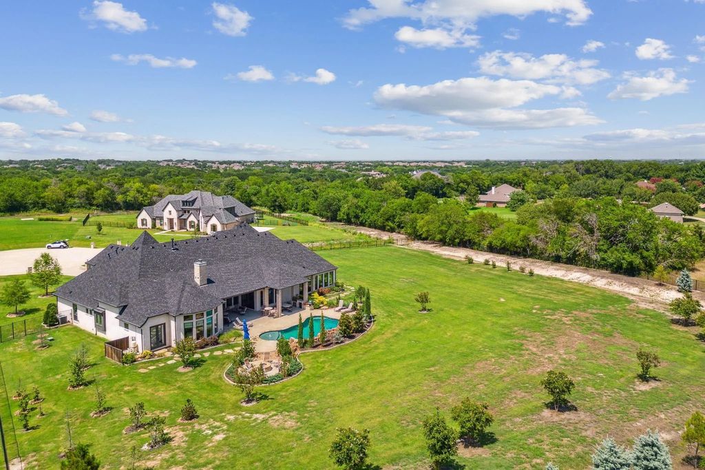 1621 Jan Marie Drive Home in Lucas, Texas. Discover unparalleled luxury in this custom J. Anthony home quietly nestled on a 2-acre north-facing cul-de-sac in prestigious Lovejoy ISD. Featuring exceptional design, premium fixtures, and abundant natural light, this home offers an open concept living area with exposed beams and a gourmet kitchen with dual islands and quartz countertops.