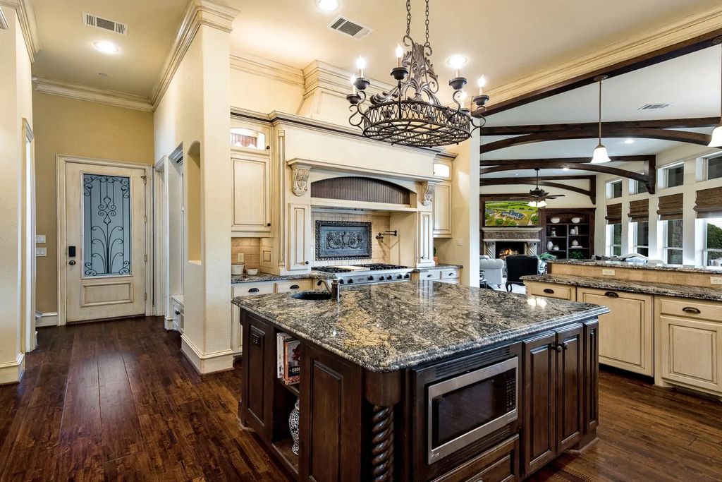 920 Broken Lance Lane Home in Rockwall, Texas. Discover the epitome of luxury living in this French-inspired estate nestled within a lakeside community near Dallas amenities. With 61 estate homes in the gated Oaks of Buffalo Way, this property exudes elegance with its wrought-iron porte cochere, NEW roof with copper turret, and 5 fireplaces.