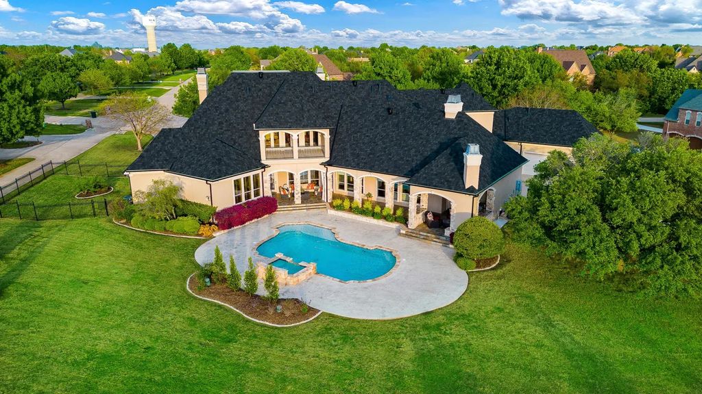920 Broken Lance Lane Home in Rockwall, Texas. Discover the epitome of luxury living in this French-inspired estate nestled within a lakeside community near Dallas amenities. With 61 estate homes in the gated Oaks of Buffalo Way, this property exudes elegance with its wrought-iron porte cochere, NEW roof with copper turret, and 5 fireplaces.