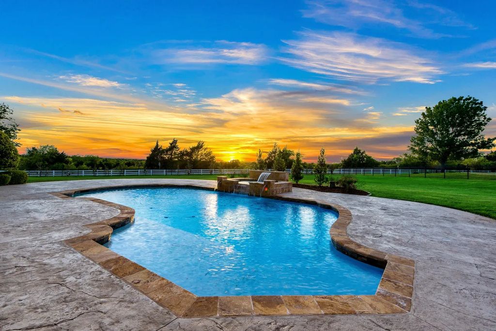 920 Broken Lance Lane Home in Rockwall, Texas. Discover the epitome of luxury living in this French-inspired estate nestled within a lakeside community near Dallas amenities. With 61 estate homes in the gated Oaks of Buffalo Way, this property exudes elegance with its wrought-iron porte cochere, NEW roof with copper turret, and 5 fireplaces.