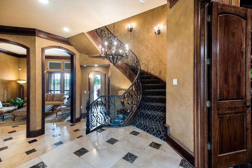 920 Broken Lance Lane Home in Rockwall, Texas. Discover the epitome of luxury living in this French-inspired estate nestled within a lakeside community near Dallas amenities. With 61 estate homes in the gated Oaks of Buffalo Way, this property exudes elegance with its wrought-iron porte cochere, NEW roof with copper turret, and 5 fireplaces.