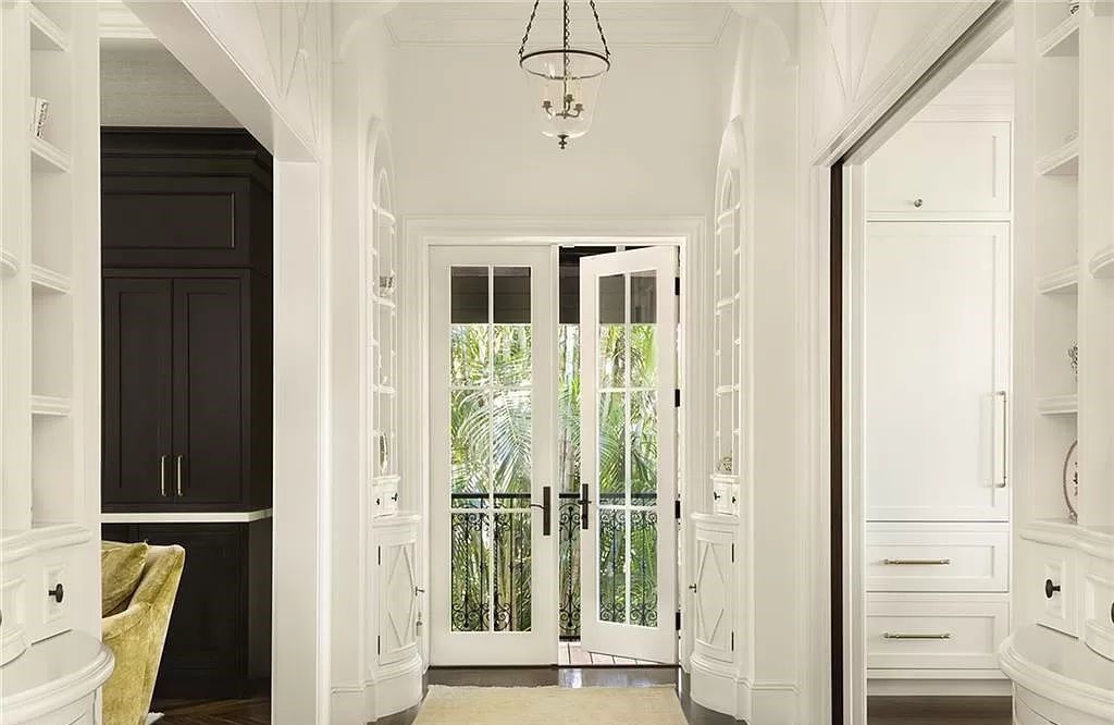 Nestled along Champney Bay in Naples, Florida, this meticulously renovated French West Indies-style estate, crafted by architect Jeff Harrell and updated by the esteemed Knauf-Koenig Group, offers a seamless blend of timeless elegance and modern luxury.