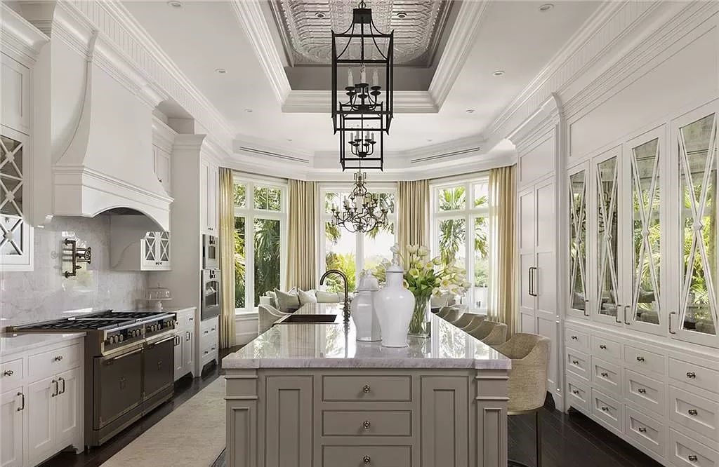 Nestled along Champney Bay in Naples, Florida, this meticulously renovated French West Indies-style estate, crafted by architect Jeff Harrell and updated by the esteemed Knauf-Koenig Group, offers a seamless blend of timeless elegance and modern luxury.