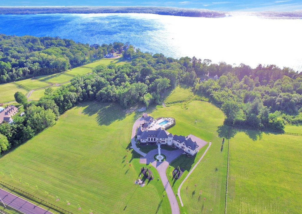 65 Brown Road Home in Stillwater, New York. Experience unparalleled luxury in this exquisite French Country Chateau nestled on 15 acres with stunning views of Saratoga Lake. Boasting 7,237 SF, this custom mansion features 5 bedroom suites, 7.5 baths, and a separate pool house with kitchenette, bathroom, and fireplace. 