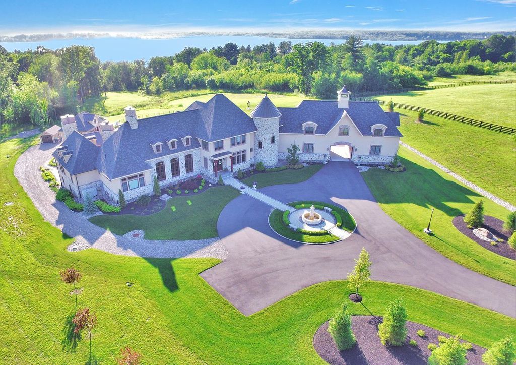 65 Brown Road Home in Stillwater, New York. Experience unparalleled luxury in this exquisite French Country Chateau nestled on 15 acres with stunning views of Saratoga Lake. Boasting 7,237 SF, this custom mansion features 5 bedroom suites, 7.5 baths, and a separate pool house with kitchenette, bathroom, and fireplace. 