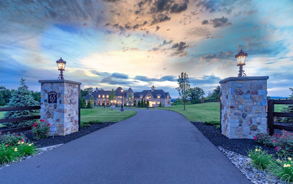 65 Brown Road Home in Stillwater, New York. Experience unparalleled luxury in this exquisite French Country Chateau nestled on 15 acres with stunning views of Saratoga Lake. Boasting 7,237 SF, this custom mansion features 5 bedroom suites, 7.5 baths, and a separate pool house with kitchenette, bathroom, and fireplace. 