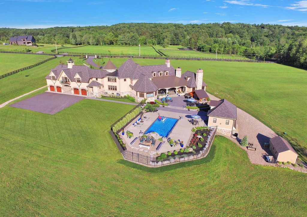 65 Brown Road Home in Stillwater, New York. Experience unparalleled luxury in this exquisite French Country Chateau nestled on 15 acres with stunning views of Saratoga Lake. Boasting 7,237 SF, this custom mansion features 5 bedroom suites, 7.5 baths, and a separate pool house with kitchenette, bathroom, and fireplace. 