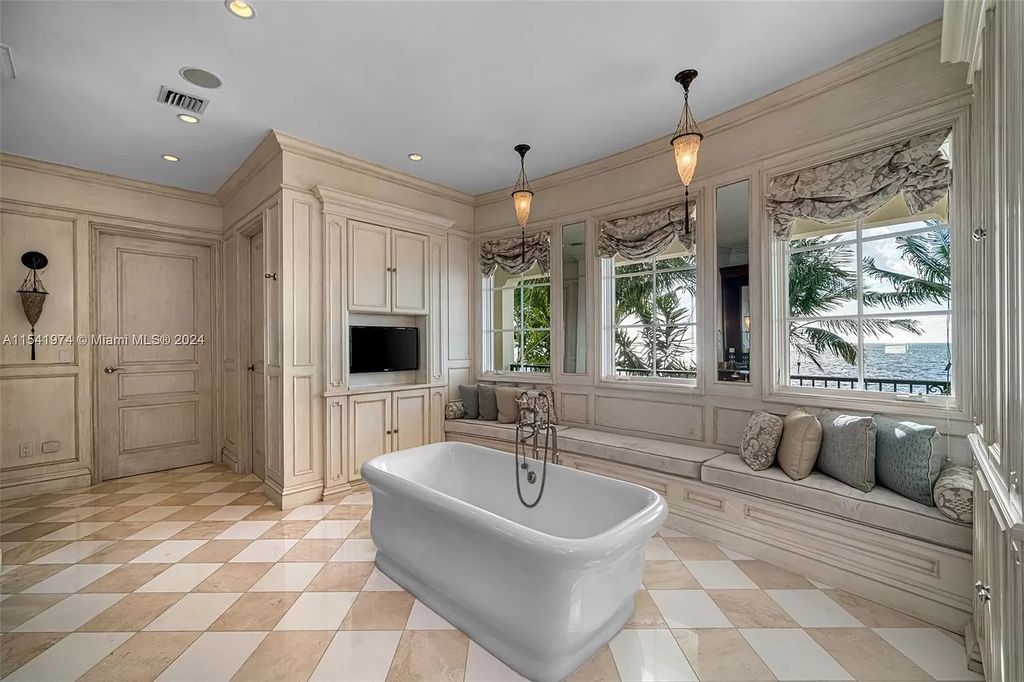 Nestled within the prestigious guard-gated community of Gables Estates, 33 Arvida Parkway presents a magnificent 14,972-square-foot estate boasting 225 feet of waterfront on a lushly landscaped 35,389-square-foot lot.