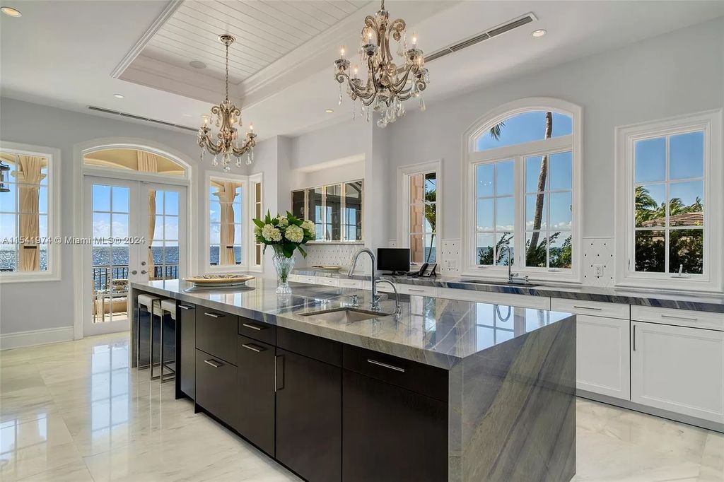 Nestled within the prestigious guard-gated community of Gables Estates, 33 Arvida Parkway presents a magnificent 14,972-square-foot estate boasting 225 feet of waterfront on a lushly landscaped 35,389-square-foot lot.