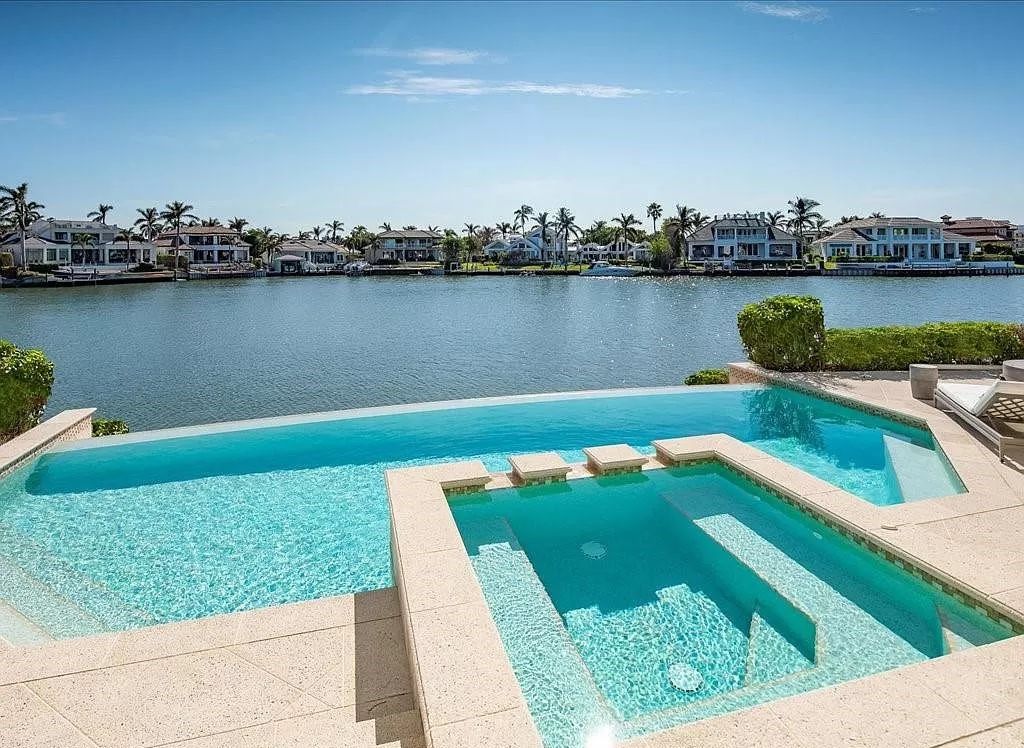 Indulge in the epitome of luxury waterfront living at this magnificent Naples estate on 210 Cuddy Ct. Crafted by Kurtz Homes, this opulent residence boasts grand columns, exquisite tile flooring, and coffered ceilings, flooded with natural light.