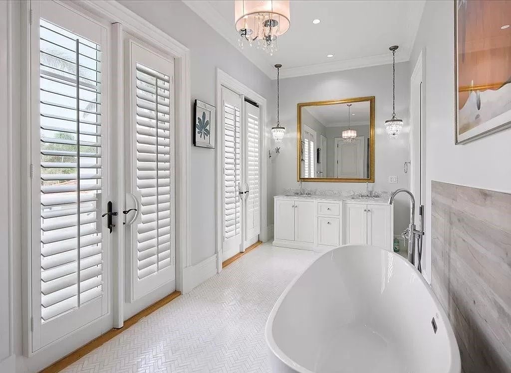 Indulge in the epitome of luxury waterfront living at this magnificent Naples estate on 210 Cuddy Ct. Crafted by Kurtz Homes, this opulent residence boasts grand columns, exquisite tile flooring, and coffered ceilings, flooded with natural light.