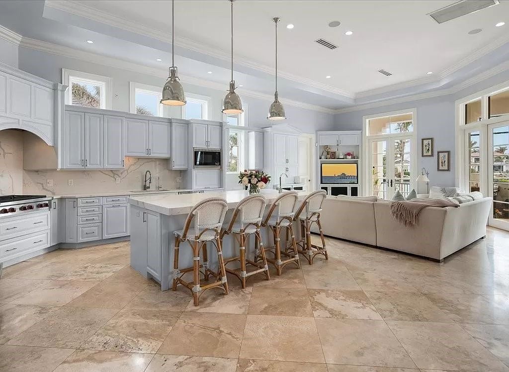 Indulge in the epitome of luxury waterfront living at this magnificent Naples estate on 210 Cuddy Ct. Crafted by Kurtz Homes, this opulent residence boasts grand columns, exquisite tile flooring, and coffered ceilings, flooded with natural light.