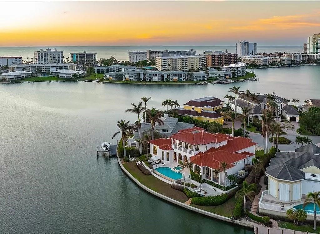 Indulge in the epitome of luxury waterfront living at this magnificent Naples estate on 210 Cuddy Ct. Crafted by Kurtz Homes, this opulent residence boasts grand columns, exquisite tile flooring, and coffered ceilings, flooded with natural light.