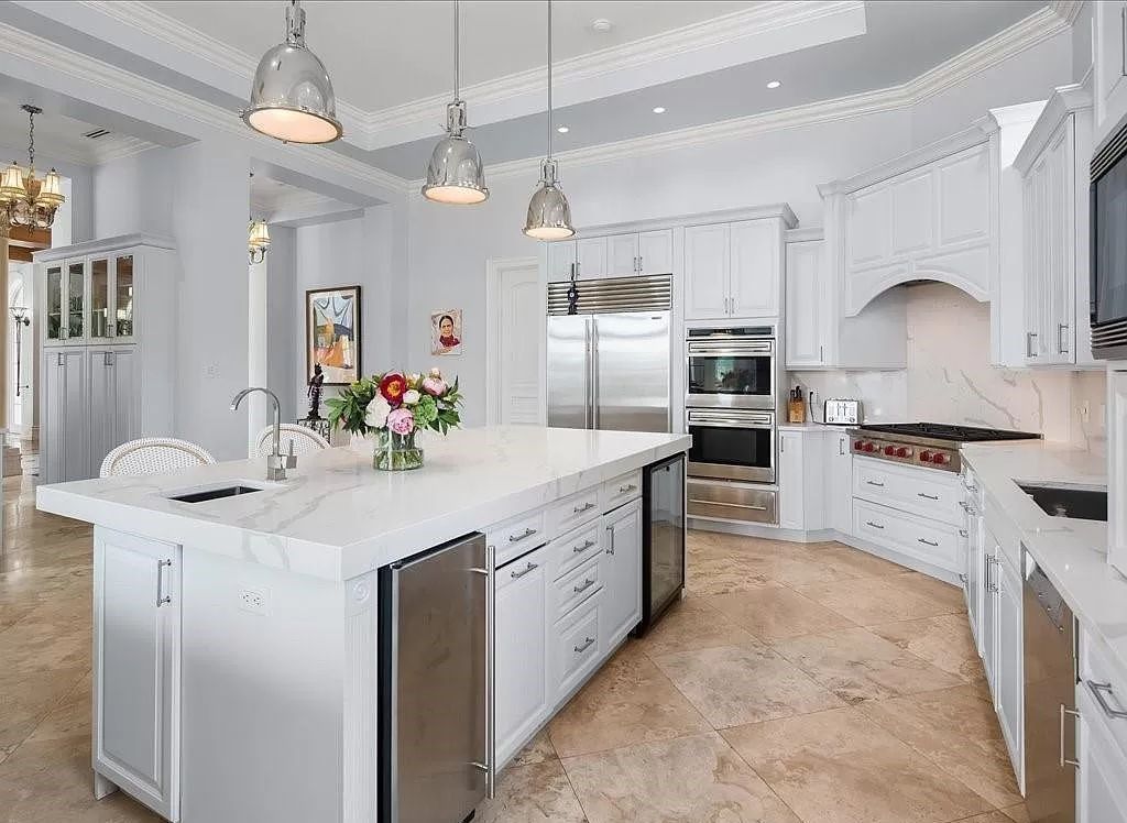 Indulge in the epitome of luxury waterfront living at this magnificent Naples estate on 210 Cuddy Ct. Crafted by Kurtz Homes, this opulent residence boasts grand columns, exquisite tile flooring, and coffered ceilings, flooded with natural light.