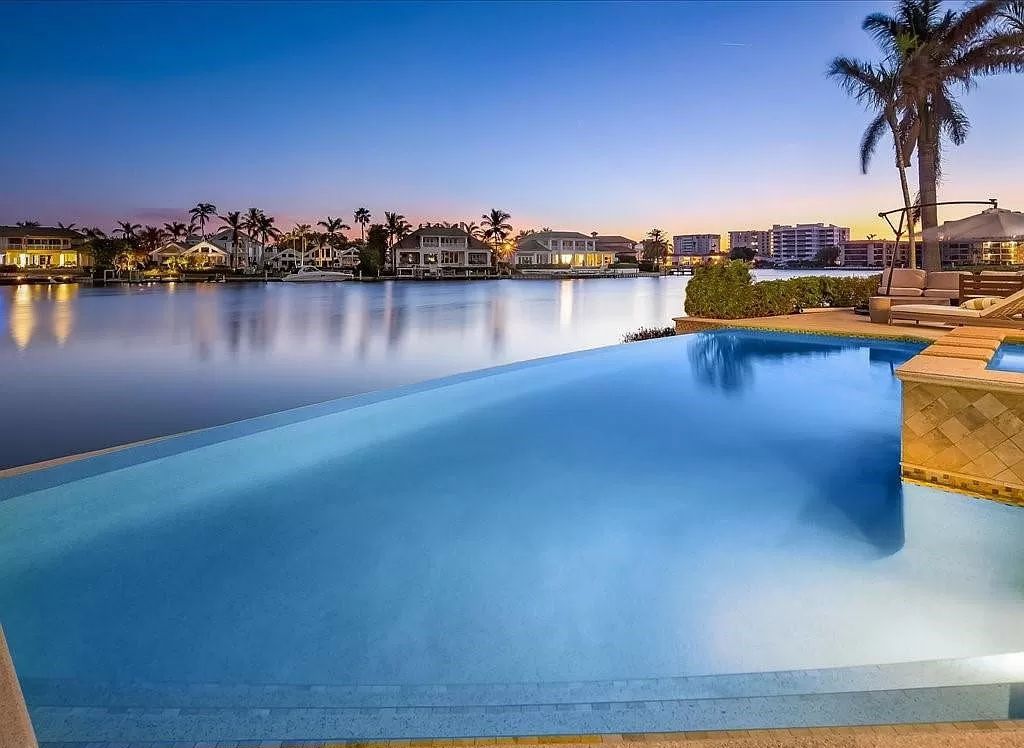 Indulge in the epitome of luxury waterfront living at this magnificent Naples estate on 210 Cuddy Ct. Crafted by Kurtz Homes, this opulent residence boasts grand columns, exquisite tile flooring, and coffered ceilings, flooded with natural light.