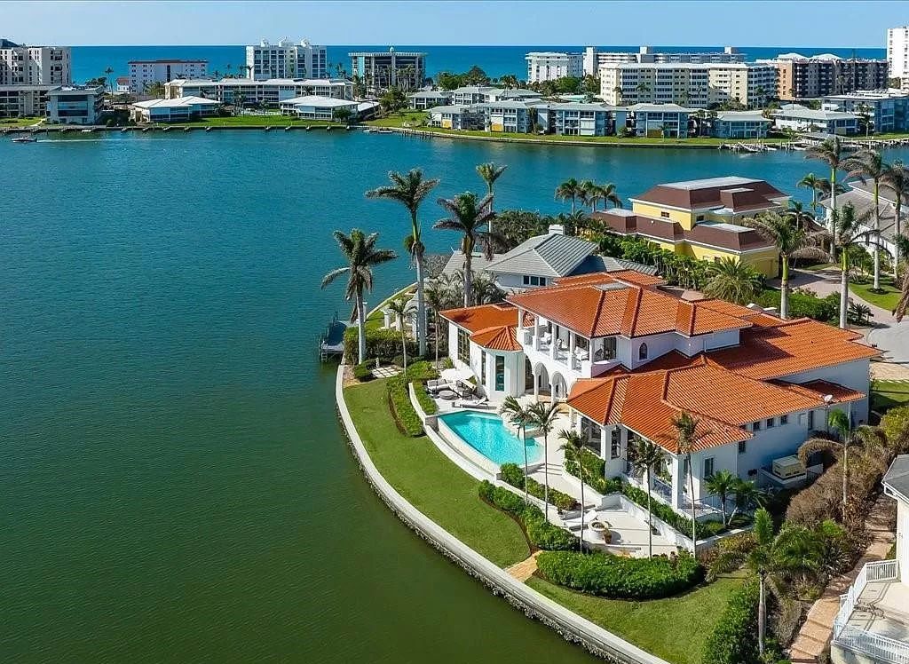 Indulge in the epitome of luxury waterfront living at this magnificent Naples estate on 210 Cuddy Ct. Crafted by Kurtz Homes, this opulent residence boasts grand columns, exquisite tile flooring, and coffered ceilings, flooded with natural light.