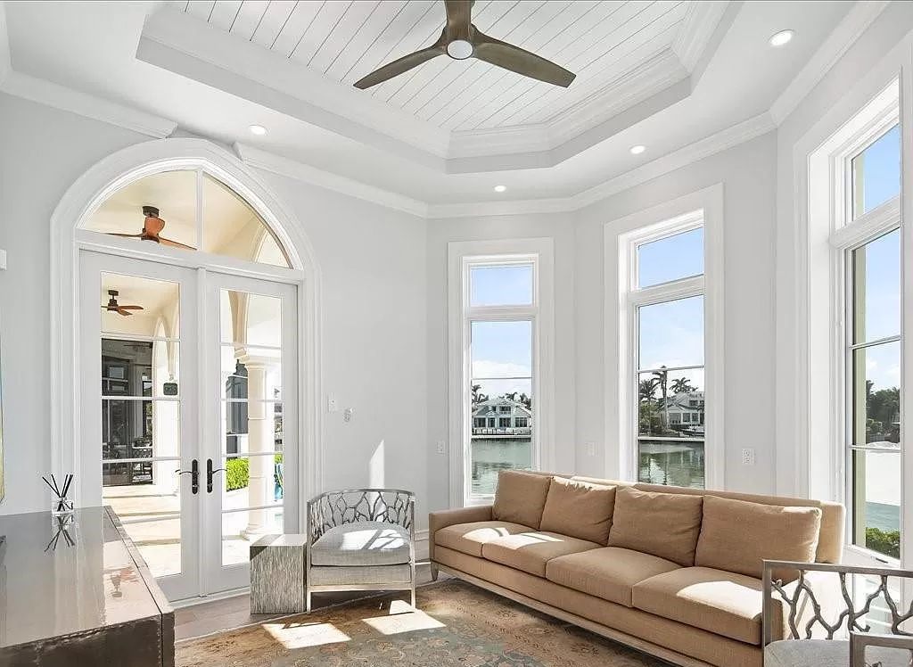 Indulge in the epitome of luxury waterfront living at this magnificent Naples estate on 210 Cuddy Ct. Crafted by Kurtz Homes, this opulent residence boasts grand columns, exquisite tile flooring, and coffered ceilings, flooded with natural light.