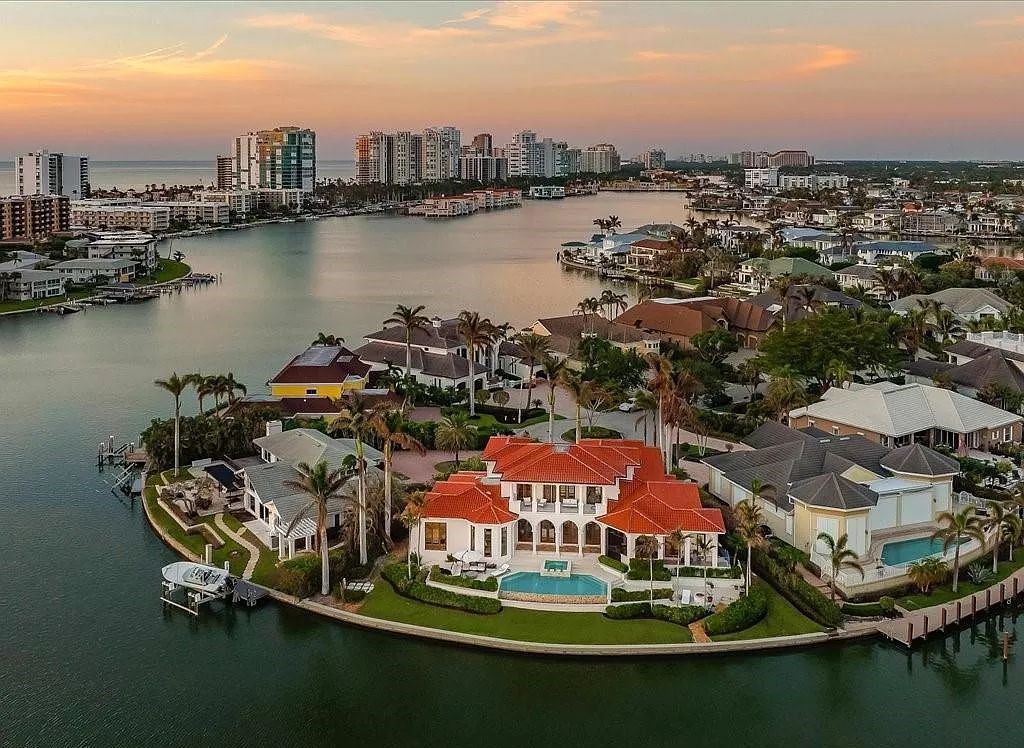 Indulge in the epitome of luxury waterfront living at this magnificent Naples estate on 210 Cuddy Ct. Crafted by Kurtz Homes, this opulent residence boasts grand columns, exquisite tile flooring, and coffered ceilings, flooded with natural light.