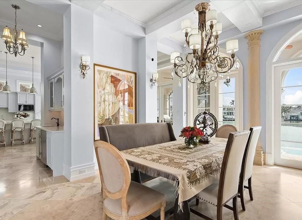 Indulge in the epitome of luxury waterfront living at this magnificent Naples estate on 210 Cuddy Ct. Crafted by Kurtz Homes, this opulent residence boasts grand columns, exquisite tile flooring, and coffered ceilings, flooded with natural light.