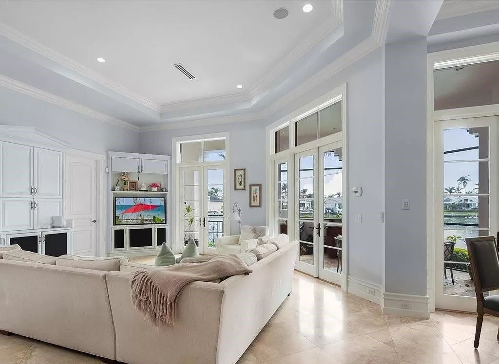 Indulge in the epitome of luxury waterfront living at this magnificent Naples estate on 210 Cuddy Ct. Crafted by Kurtz Homes, this opulent residence boasts grand columns, exquisite tile flooring, and coffered ceilings, flooded with natural light.