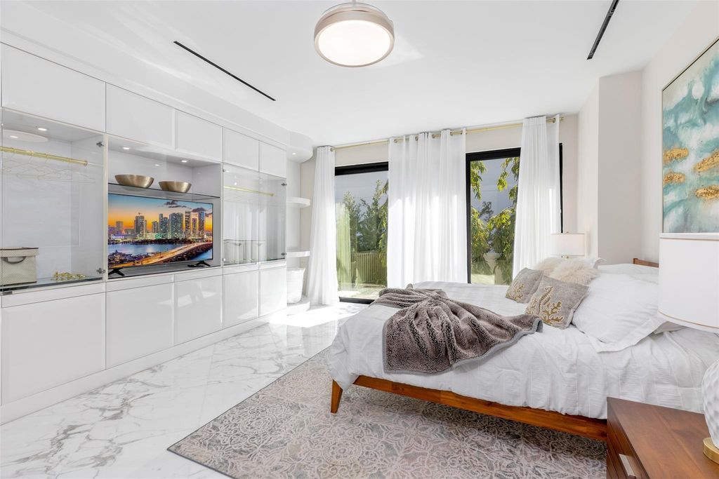 Rebuilt in July 2023, this single-story smart home offers 5,073 square feet of sophisticated living space on a sprawling 15,300-square-foot lot with a 2,300-square-foot dock adorned with coral stone from Spain.