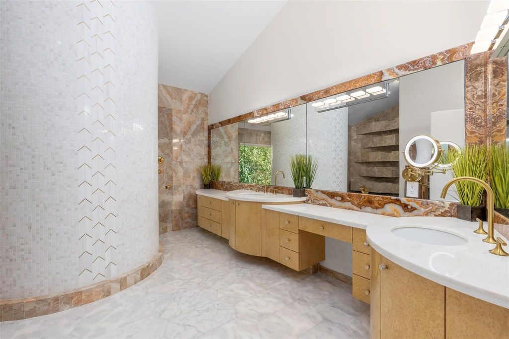 Rebuilt in July 2023, this single-story smart home offers 5,073 square feet of sophisticated living space on a sprawling 15,300-square-foot lot with a 2,300-square-foot dock adorned with coral stone from Spain.