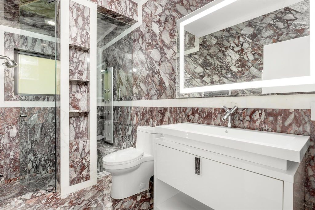 Rebuilt in July 2023, this single-story smart home offers 5,073 square feet of sophisticated living space on a sprawling 15,300-square-foot lot with a 2,300-square-foot dock adorned with coral stone from Spain.