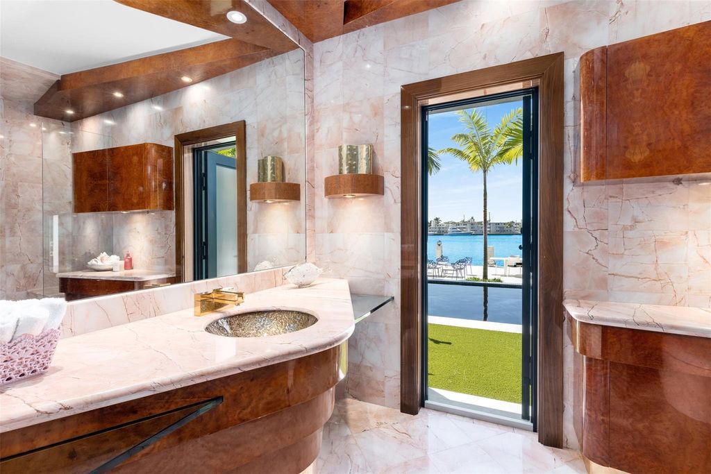 Rebuilt in July 2023, this single-story smart home offers 5,073 square feet of sophisticated living space on a sprawling 15,300-square-foot lot with a 2,300-square-foot dock adorned with coral stone from Spain.