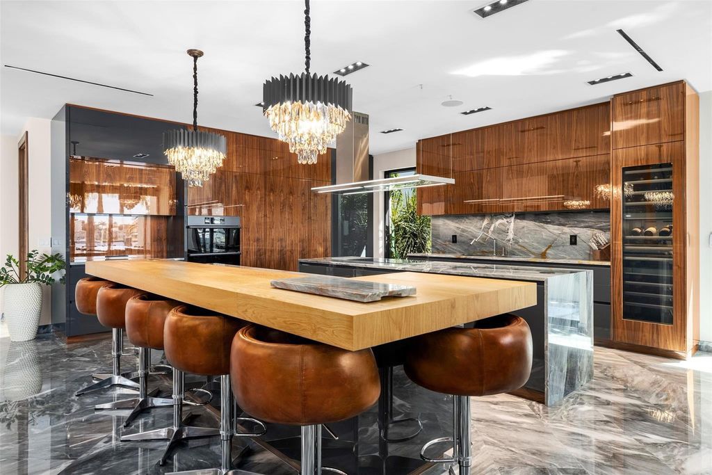 Rebuilt in July 2023, this single-story smart home offers 5,073 square feet of sophisticated living space on a sprawling 15,300-square-foot lot with a 2,300-square-foot dock adorned with coral stone from Spain.