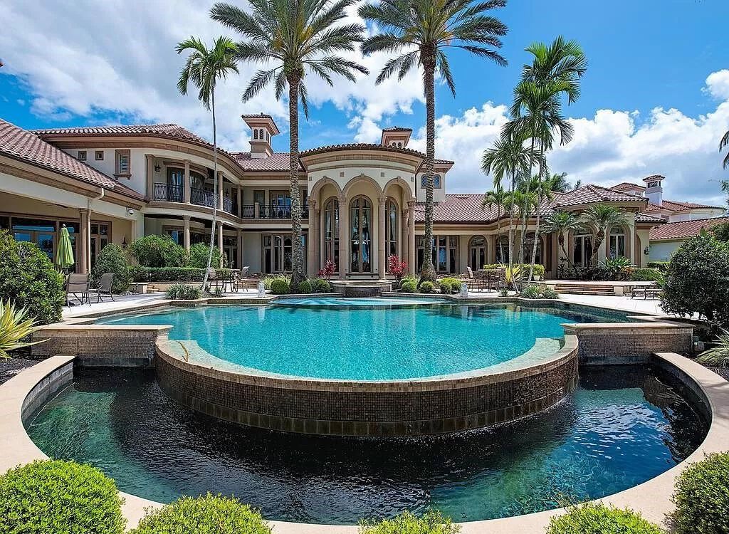 Discover unparalleled luxury living in the prestigious Estates at Bay Colony with this exquisite European-inspired residence nestled on a double lakefront estate.