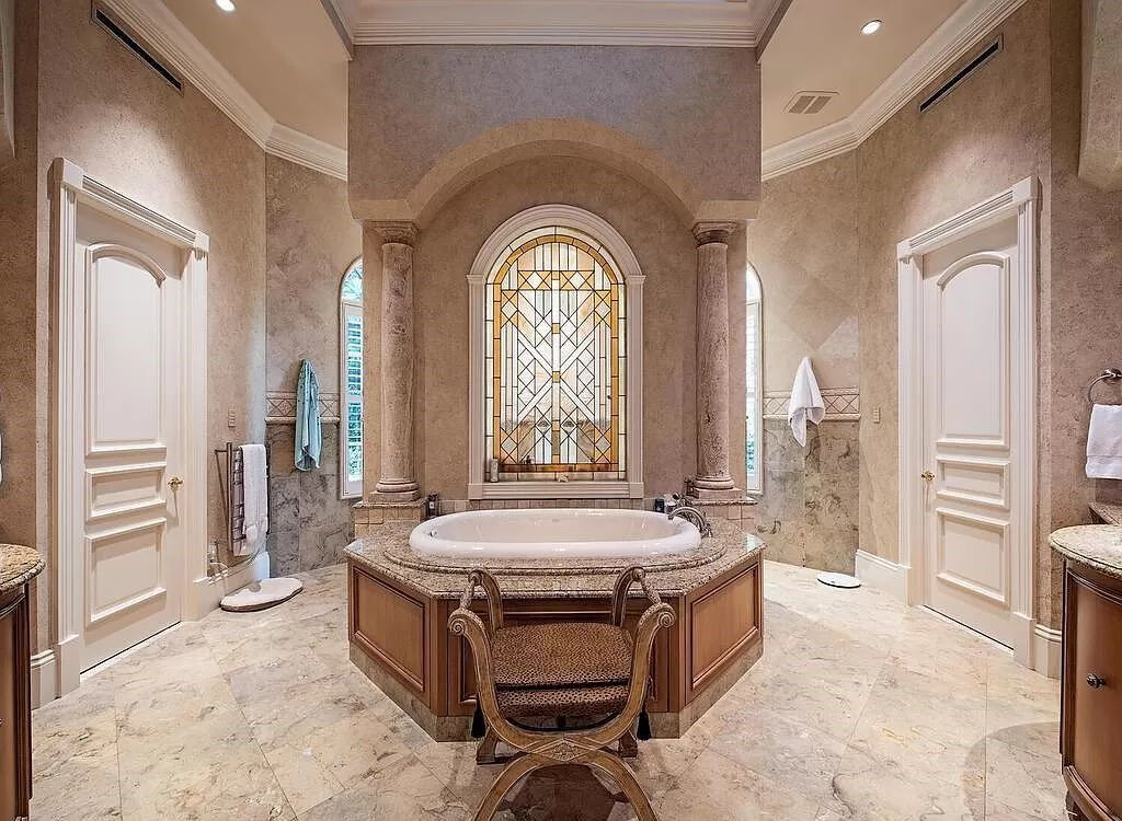 Discover unparalleled luxury living in the prestigious Estates at Bay Colony with this exquisite European-inspired residence nestled on a double lakefront estate.