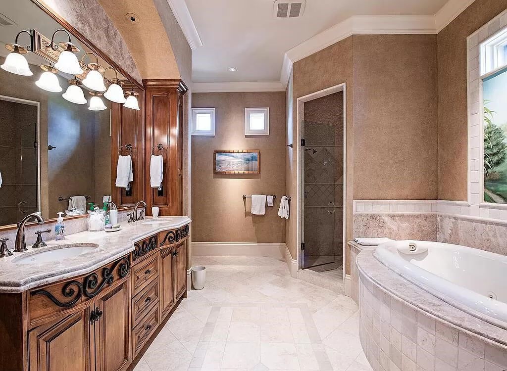 Discover unparalleled luxury living in the prestigious Estates at Bay Colony with this exquisite European-inspired residence nestled on a double lakefront estate.
