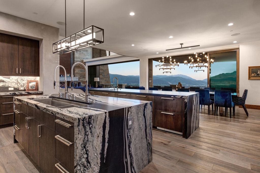 831 N Explorer Peak Drive Home in Heber, Utah. Perched atop the highest ridge within the exclusive confines of Red Ledges, this estate offers unparalleled vistas of the Mountain West. Crafted by renowned architect Michael Upwall, this residence redefines mountain modern living. 