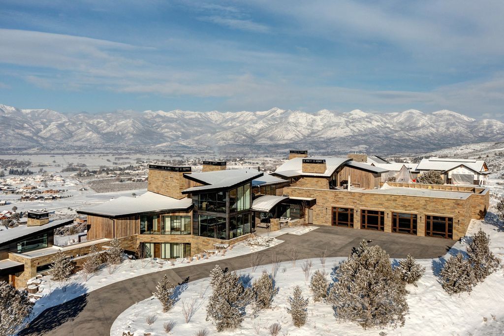 831 N Explorer Peak Drive Home in Heber, Utah. Perched atop the highest ridge within the exclusive confines of Red Ledges, this estate offers unparalleled vistas of the Mountain West. Crafted by renowned architect Michael Upwall, this residence redefines mountain modern living. 