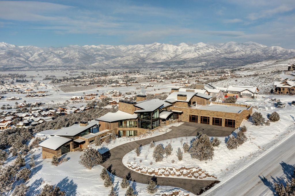 831 N Explorer Peak Drive Home in Heber, Utah. Perched atop the highest ridge within the exclusive confines of Red Ledges, this estate offers unparalleled vistas of the Mountain West. Crafted by renowned architect Michael Upwall, this residence redefines mountain modern living. 