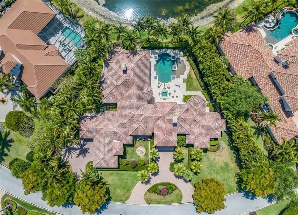 Discover an exquisite 6,500 sq ft single-level home at 2116 Canna Way, Naples, FL, set on a stunning 0.78-acre lot with picturesque lake and golf course views.