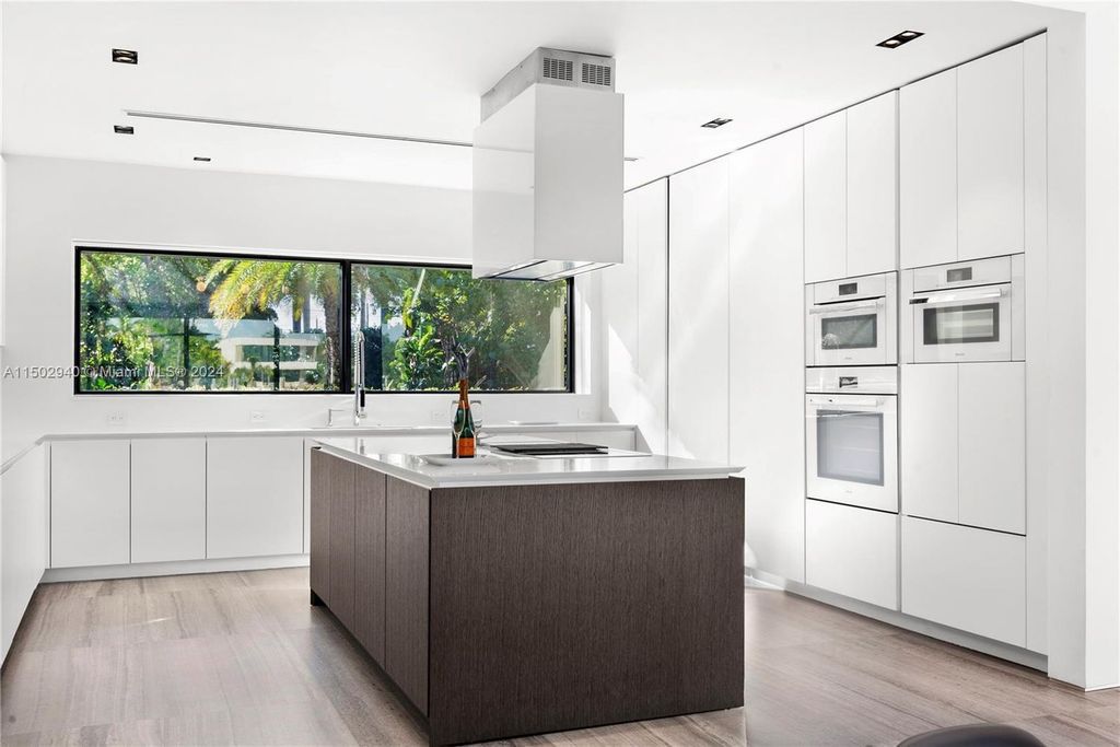 Discover unparalleled luxury in this modern masterpiece on guard-gated Biscayne Point Island. This exquisitely renovated home offers wide bay sunset views from a private peninsula with 360 feet of water frontage.
