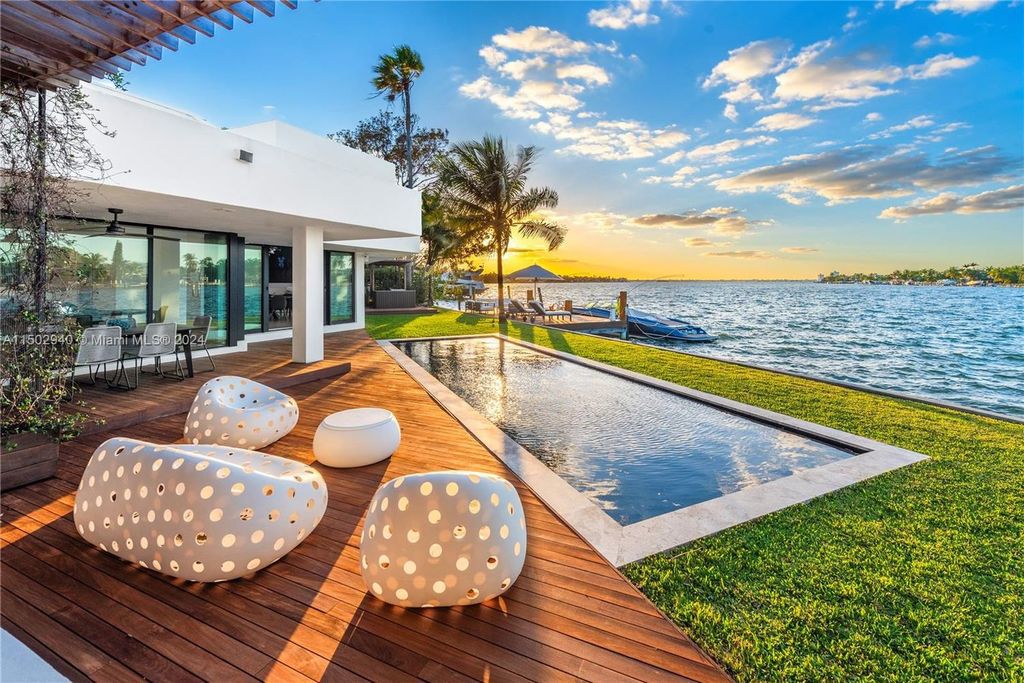 Discover unparalleled luxury in this modern masterpiece on guard-gated Biscayne Point Island. This exquisitely renovated home offers wide bay sunset views from a private peninsula with 360 feet of water frontage.