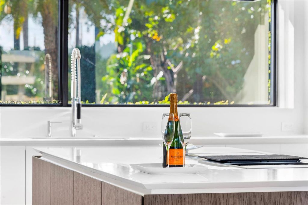 Discover unparalleled luxury in this modern masterpiece on guard-gated Biscayne Point Island. This exquisitely renovated home offers wide bay sunset views from a private peninsula with 360 feet of water frontage.