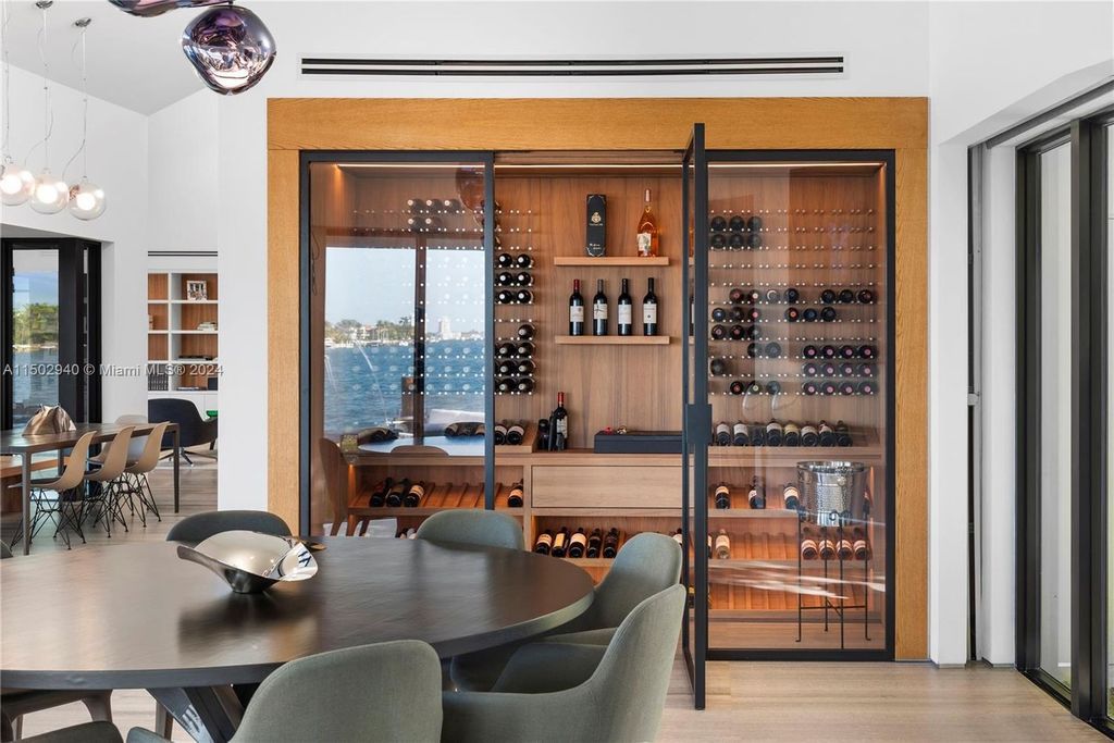 Discover unparalleled luxury in this modern masterpiece on guard-gated Biscayne Point Island. This exquisitely renovated home offers wide bay sunset views from a private peninsula with 360 feet of water frontage.