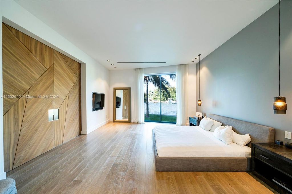 Discover unparalleled luxury in this modern masterpiece on guard-gated Biscayne Point Island. This exquisitely renovated home offers wide bay sunset views from a private peninsula with 360 feet of water frontage.
