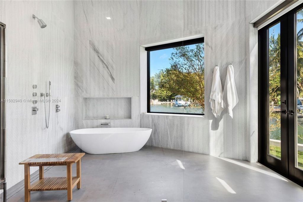 Discover unparalleled luxury in this modern masterpiece on guard-gated Biscayne Point Island. This exquisitely renovated home offers wide bay sunset views from a private peninsula with 360 feet of water frontage.