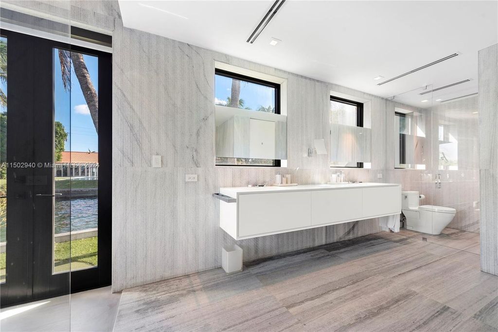 Discover unparalleled luxury in this modern masterpiece on guard-gated Biscayne Point Island. This exquisitely renovated home offers wide bay sunset views from a private peninsula with 360 feet of water frontage.