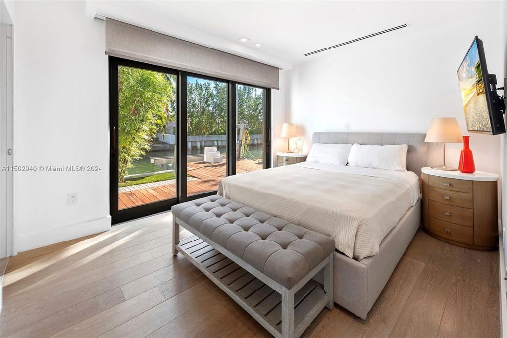 Discover unparalleled luxury in this modern masterpiece on guard-gated Biscayne Point Island. This exquisitely renovated home offers wide bay sunset views from a private peninsula with 360 feet of water frontage.